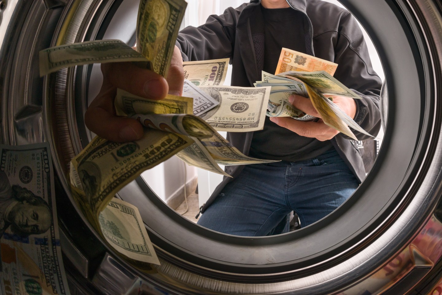 male throwing money into a washing machine