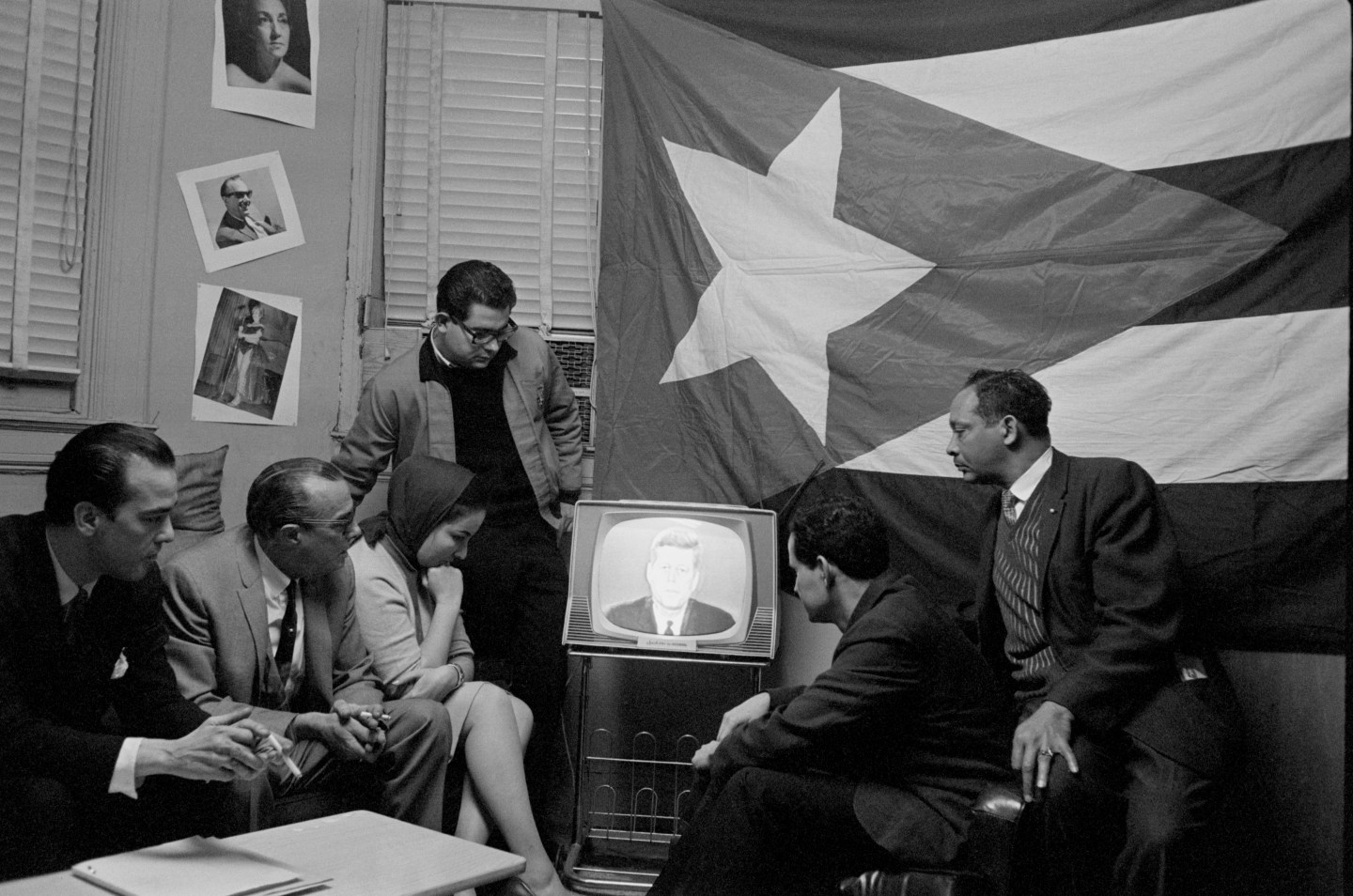 A group of Cuban refugees in Manhattan watch President Kennedy delivering a speech on television in 1962. Kennedy described a seven-point program directed at Cuba, including a quarantine. Kennedy also warned the Soviet Union against provoking any Cuban attacks.