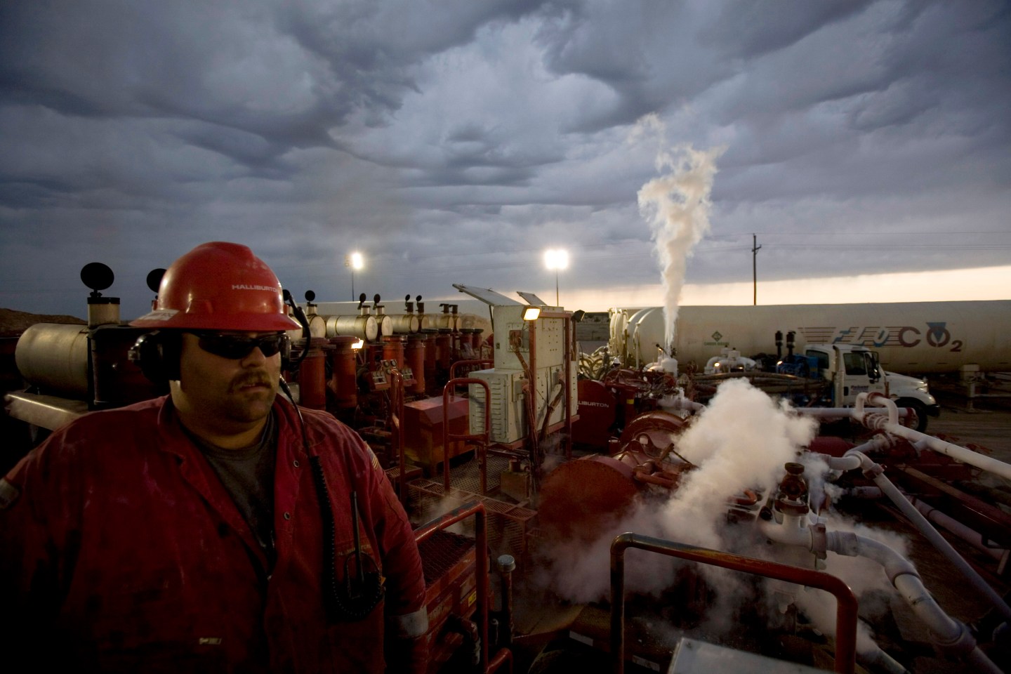 An employee of Halliburton Company monitors a series of heavy duty pressure pumps for liquid carbon dioxide at a natural gas well site on June 4, 2007, outside of Hope, in eastern New Mexico.