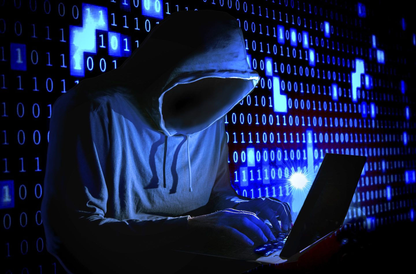 Artistic depiction of a hacker, a hooded figure in a dark room