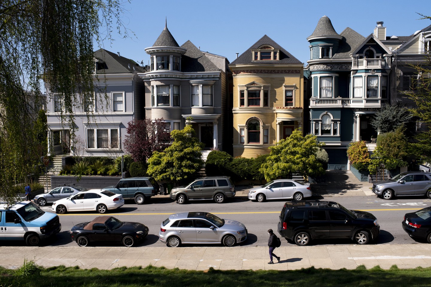 A pedestrian walks along a residential street in San Francisco