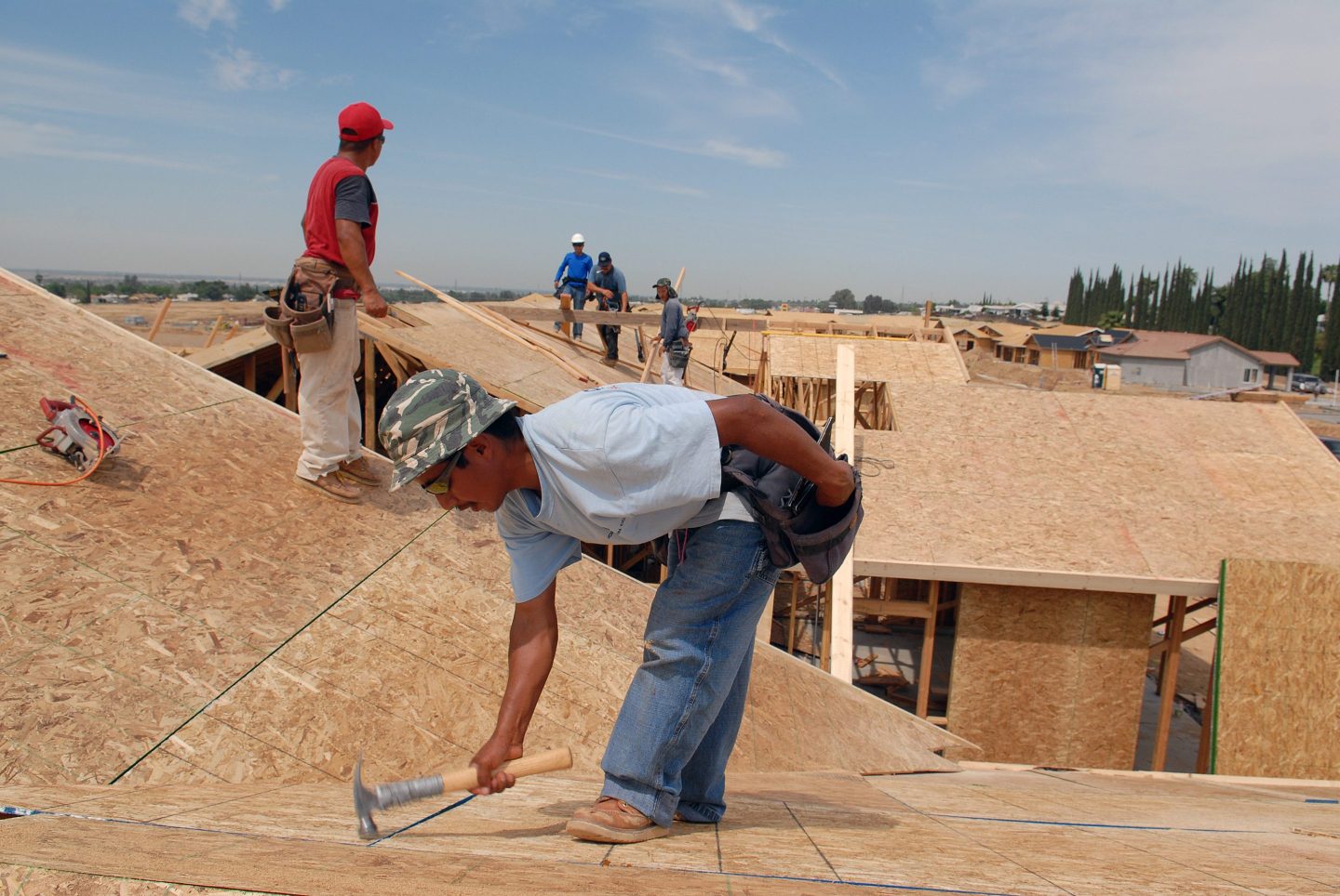 Men work on the roof of a new home in California.