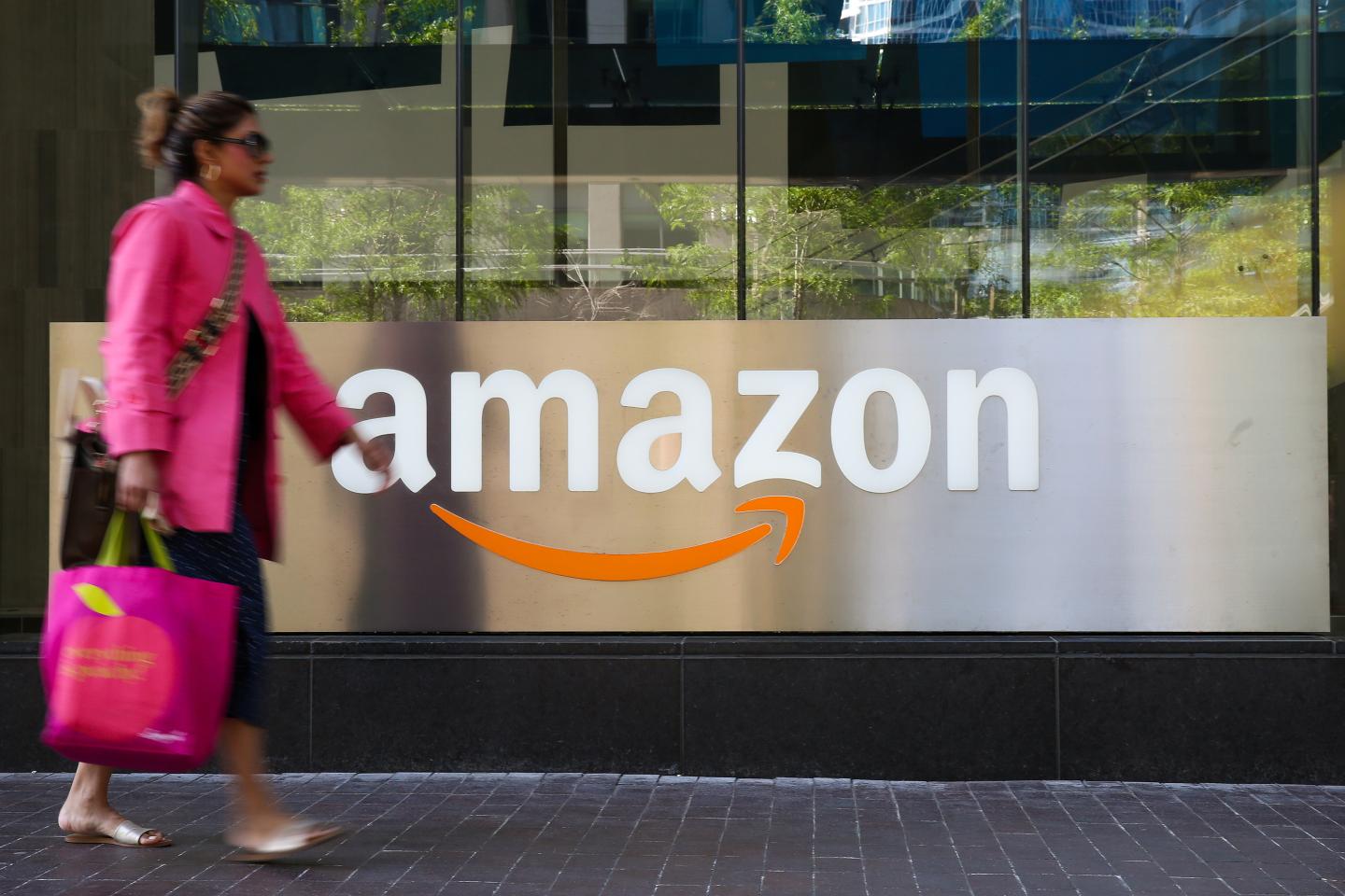 Woman walks past Amazon logo in Toronto.