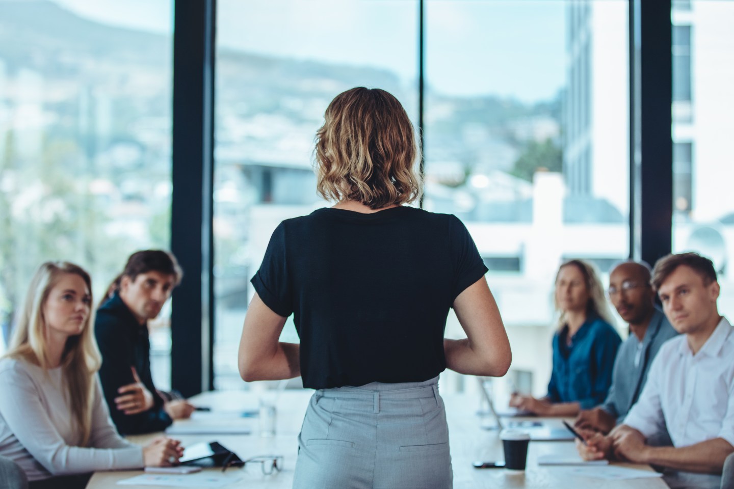 Woman addressing a meeting in office boardroom.