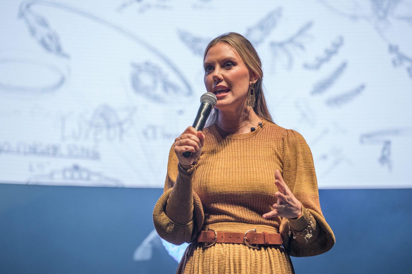 Kendra Scott speaks on a microphone