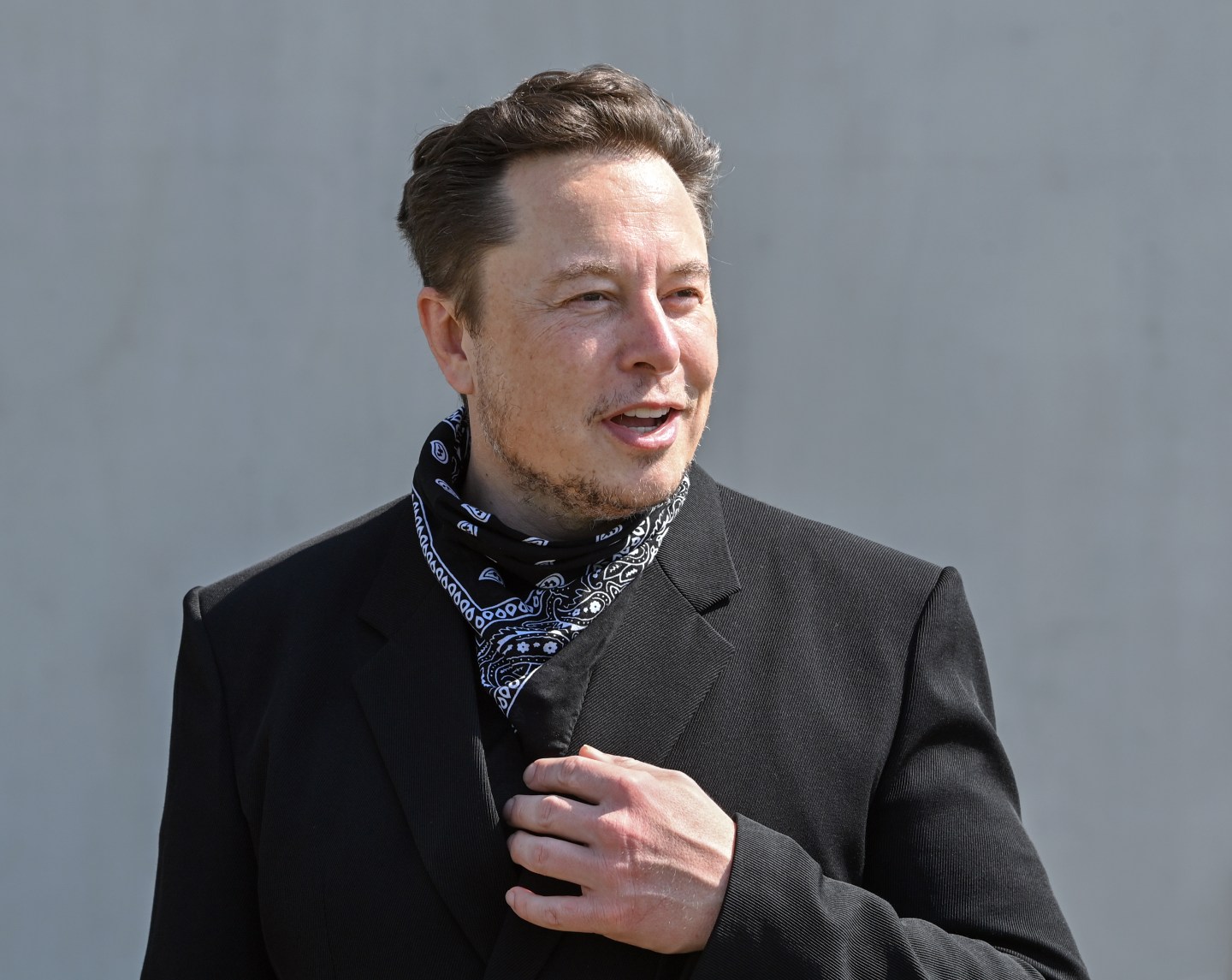 Elon Musk, Tesla CEO, stands at a press event.