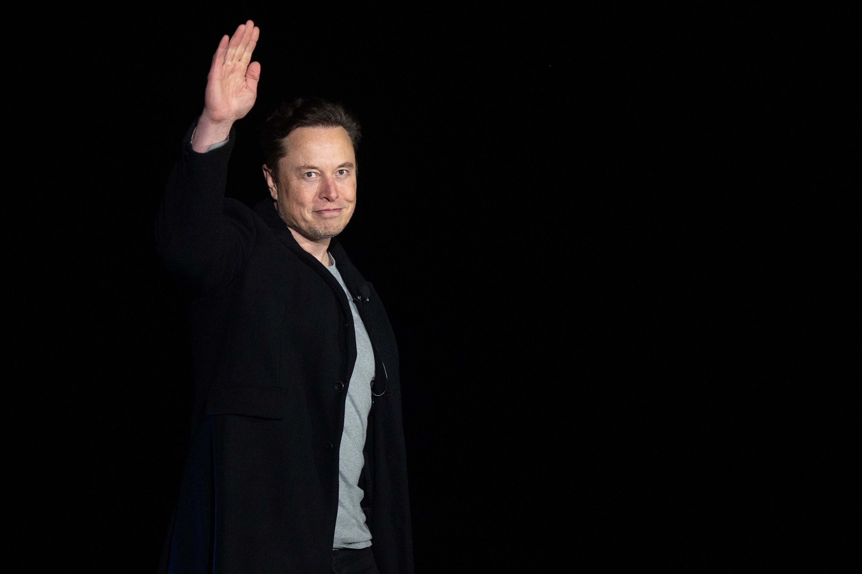 Tesla CEO Elon Musk waves during a press conference