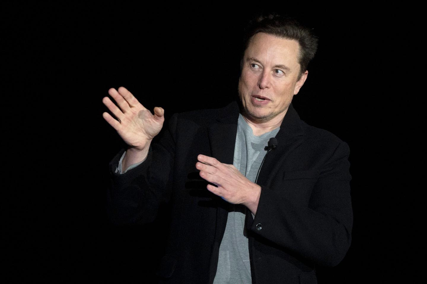 Elon Musk gestures as he speaks during a press conference
