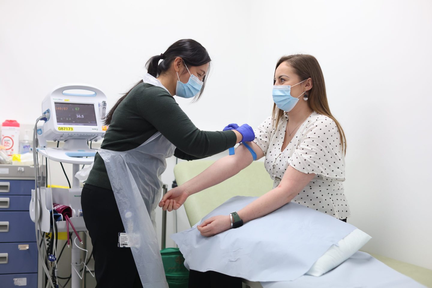 A nurse in London ties a tourniquet on a patient’s arm, preparing to draw a blood sample