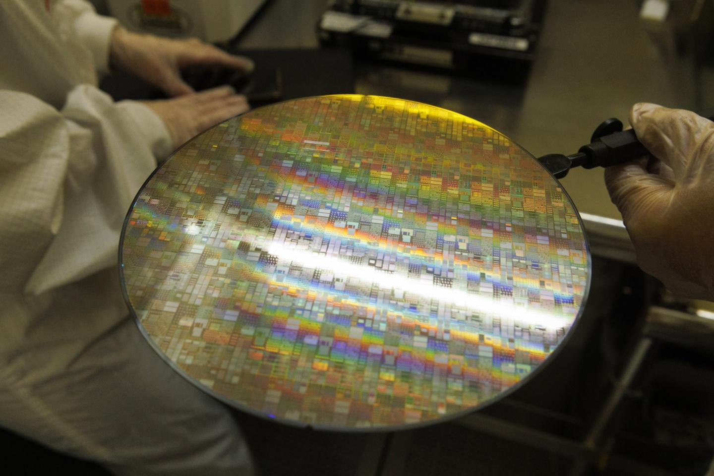 Technicians inspect a semiconductor wafer