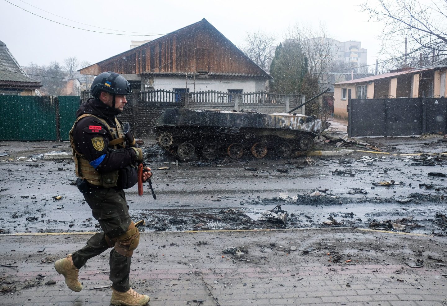 A Ukranian soldier walks past wreckage of a Russian armored vehicle