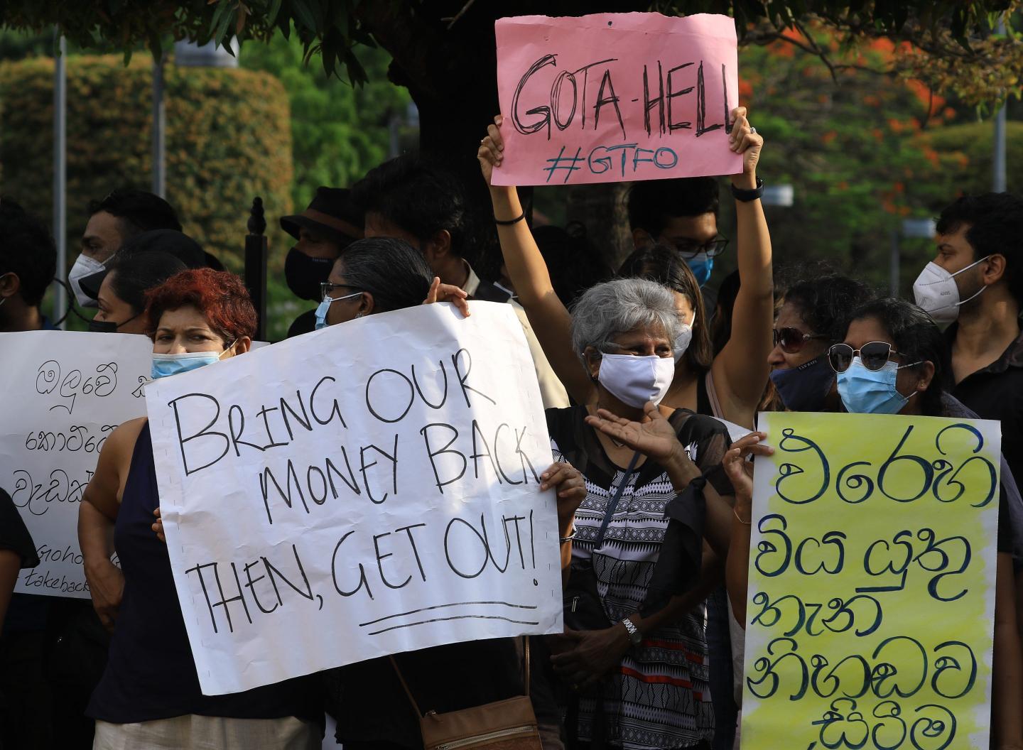 A Sri Lankan protestor holds a sign criticizing the government's economic policy
