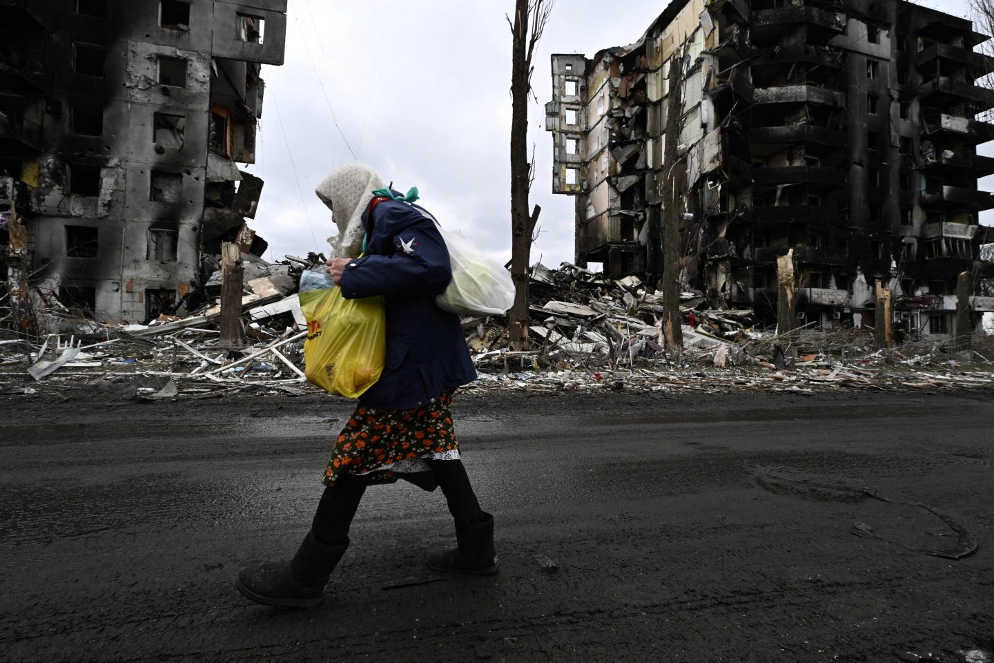 Woman walks in front of destroyed buildings in Ukraine
