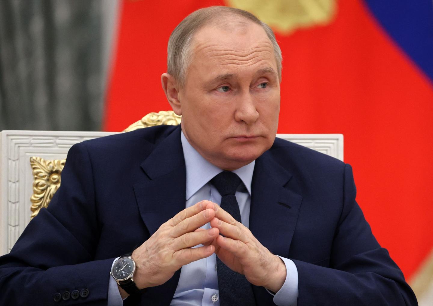 Russian President Vladimir Putin joins his hands as he holds a meeting of the Russia - Land of Opportunity platform supervisory board at the Catherine's Hall of the Kremlin in Moscow on April 20, 2022.