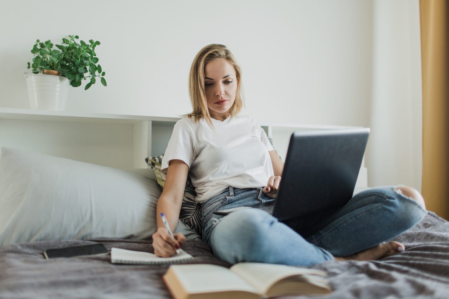 Woman writing on bed