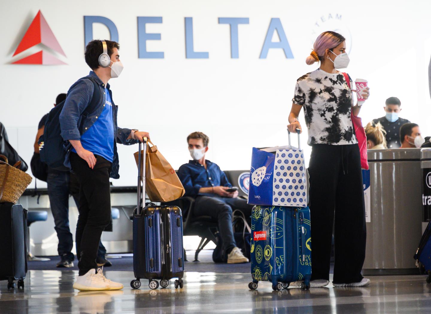 Air travelers stand by a boarding gate in John F. Kennedy International Airport.