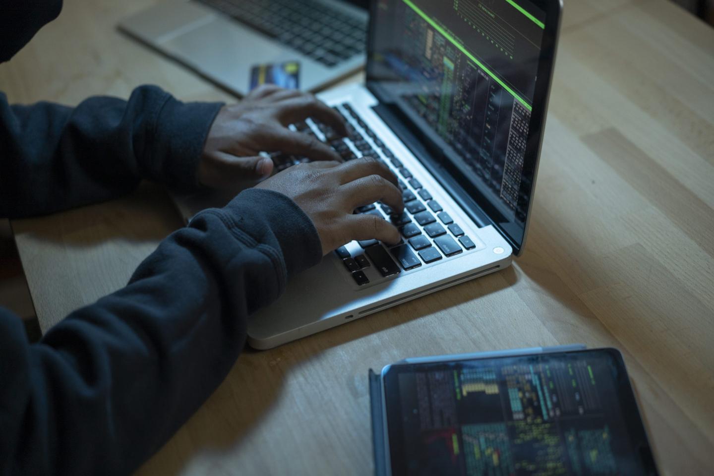 Close-up of hands typing on laptop.