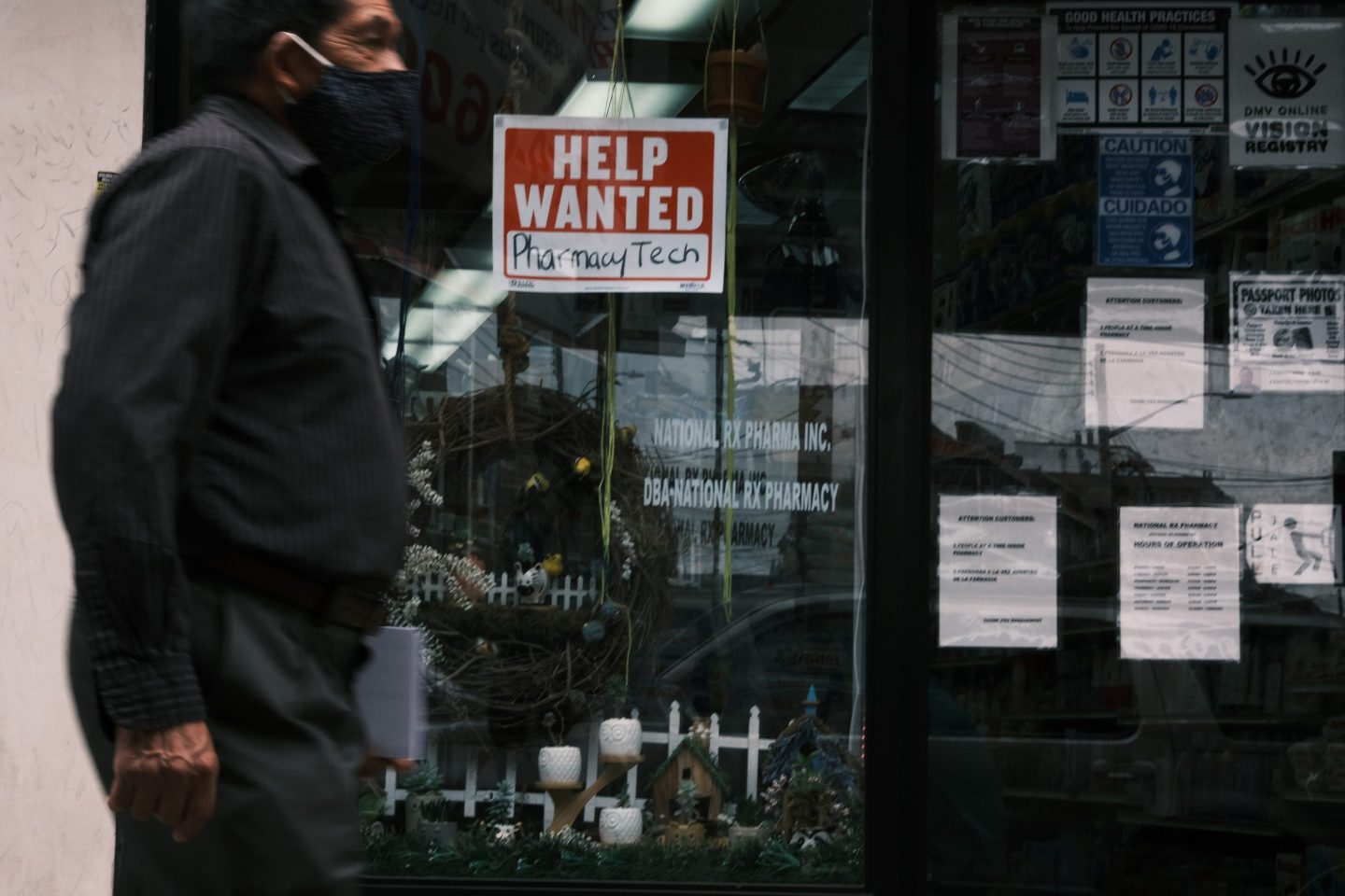 Man walks past help wanted sign