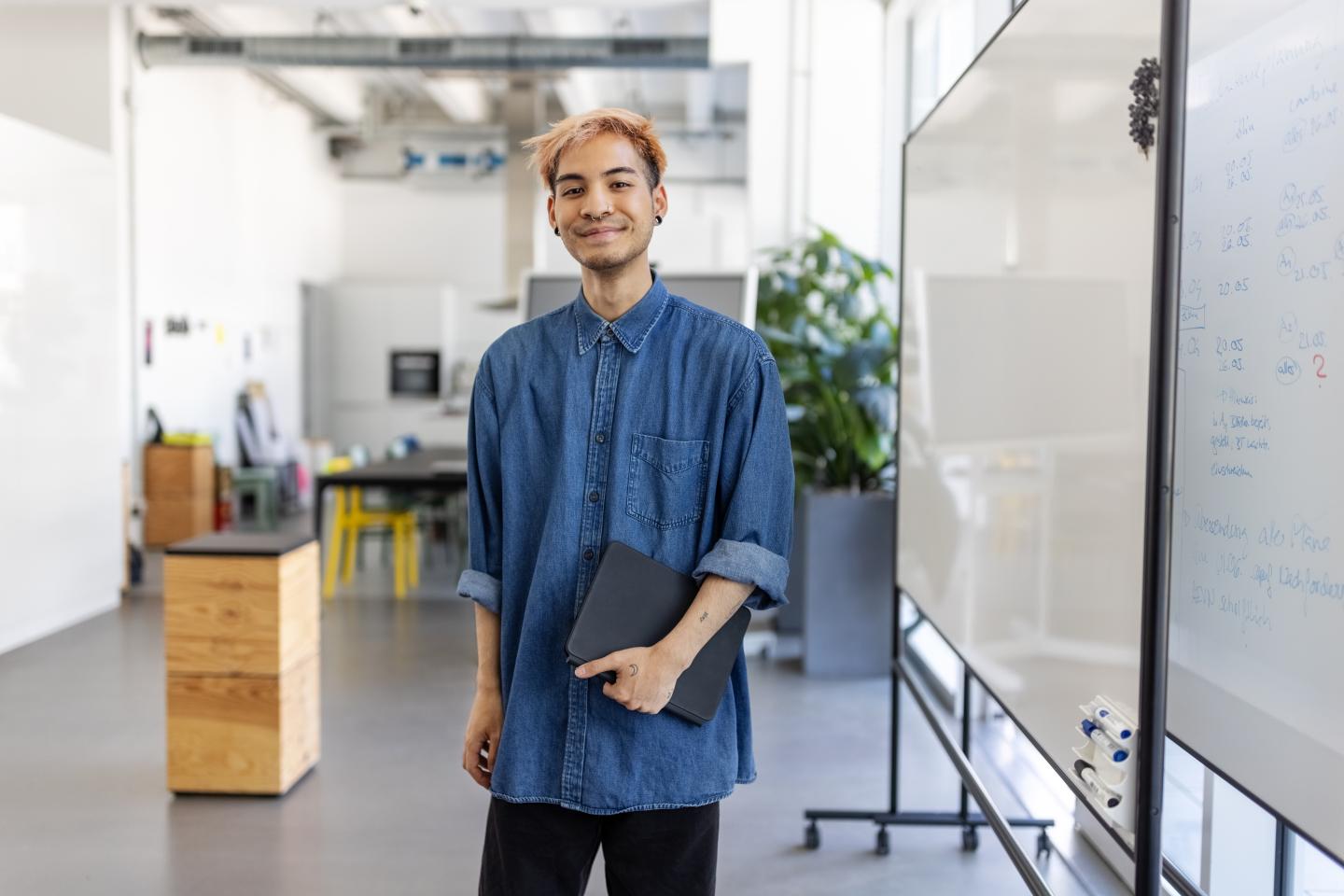A young man standing in an office.