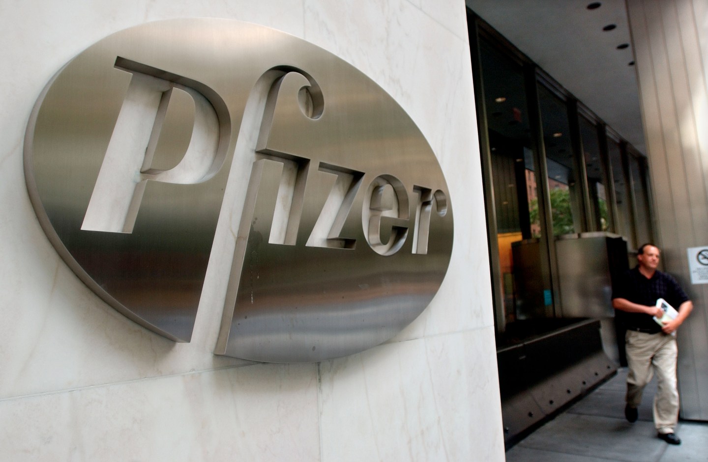 A man walks out of the Pfizer Inc. world headquarters building July 15, 2002 in New York City.