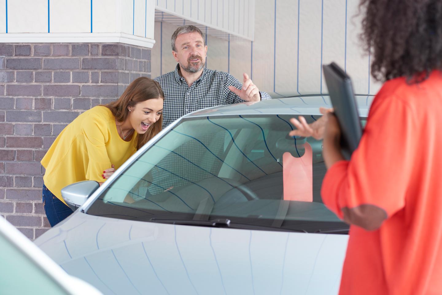 People looking at used cars.