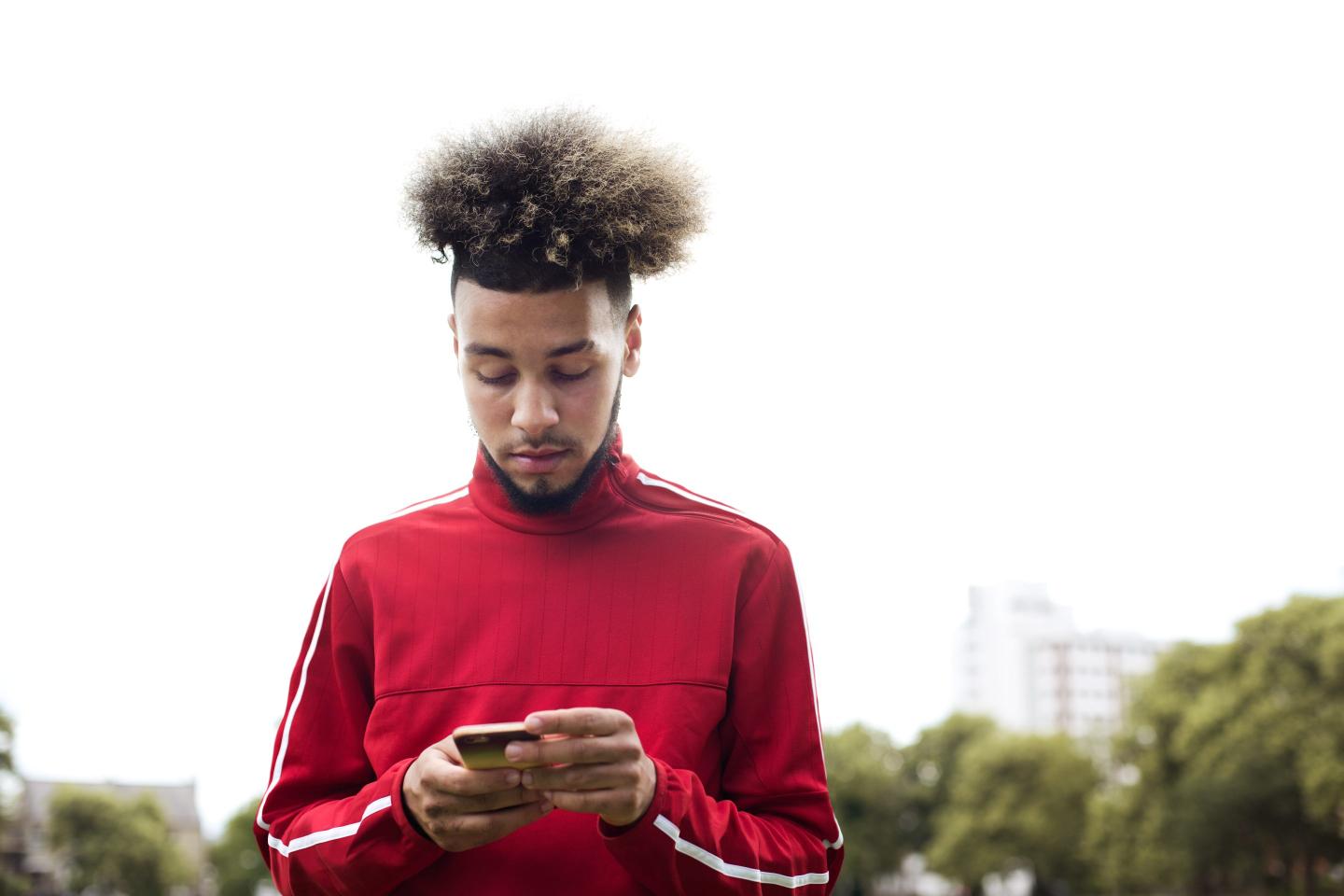 Black man texting on a cell phone.