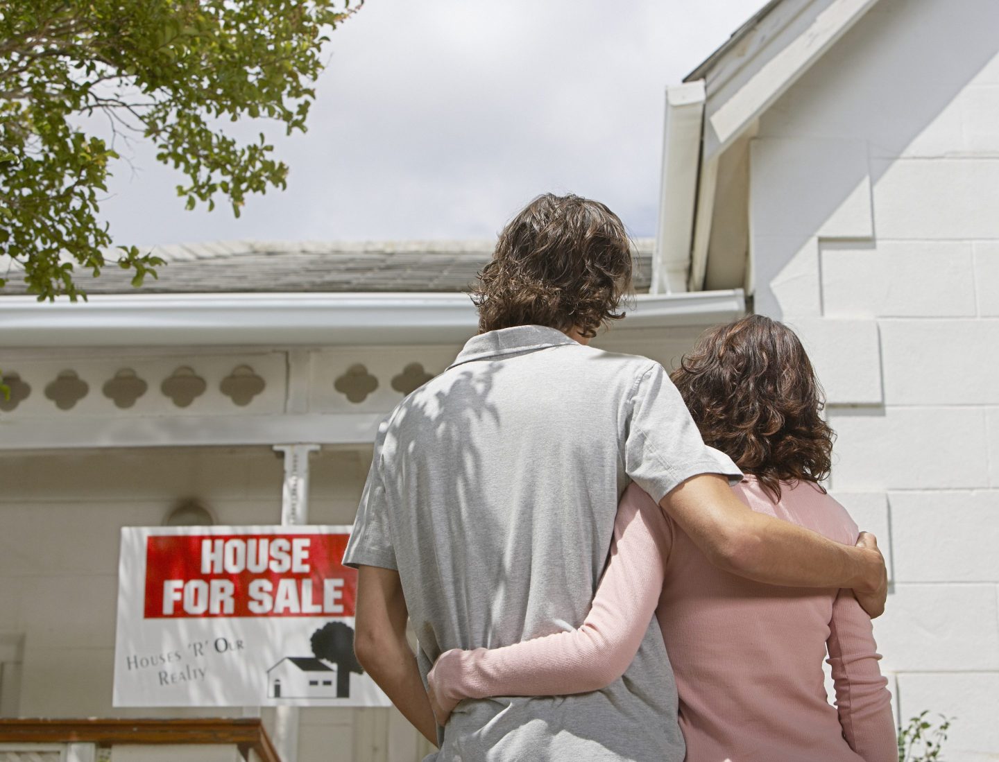 Couple stands looking at home for sale