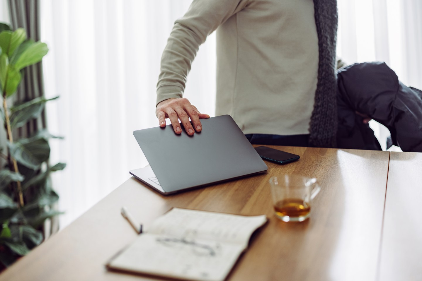 Close-up photo of businessman closing a laptop computer while walking away.