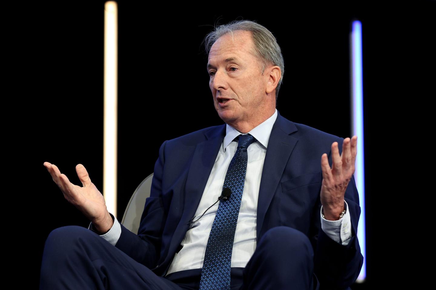 chairman and CEO of Morgan Stanley James Gorman on stage with hands raised while talking.