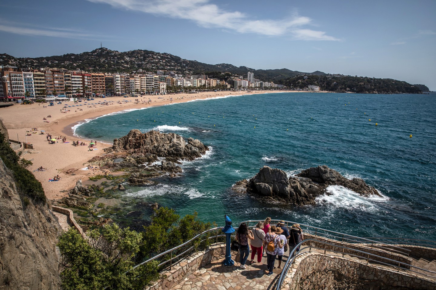 Tourists on a coastal walkway near Lloret beach in Lloret de Mar, Spain.