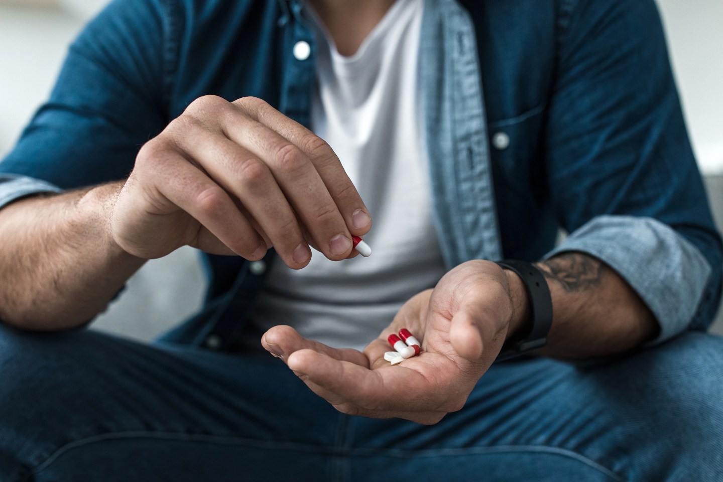 Male holding pills.