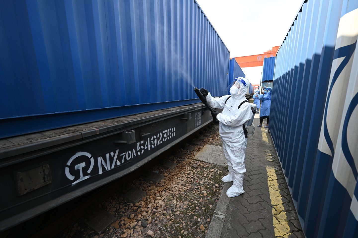 A man sprays disinfectant on a train car