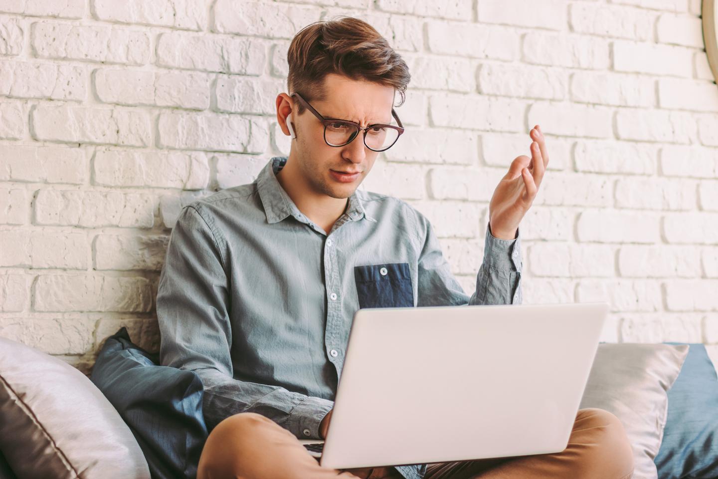 Angry confused businessman freelancer feel irritated while use laptop for work at home.