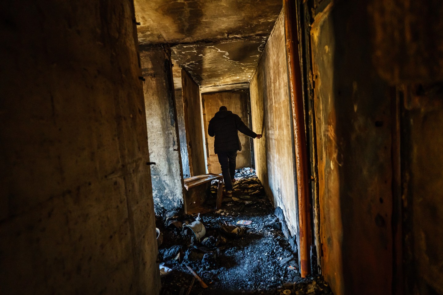 A man walks through a damaged building.