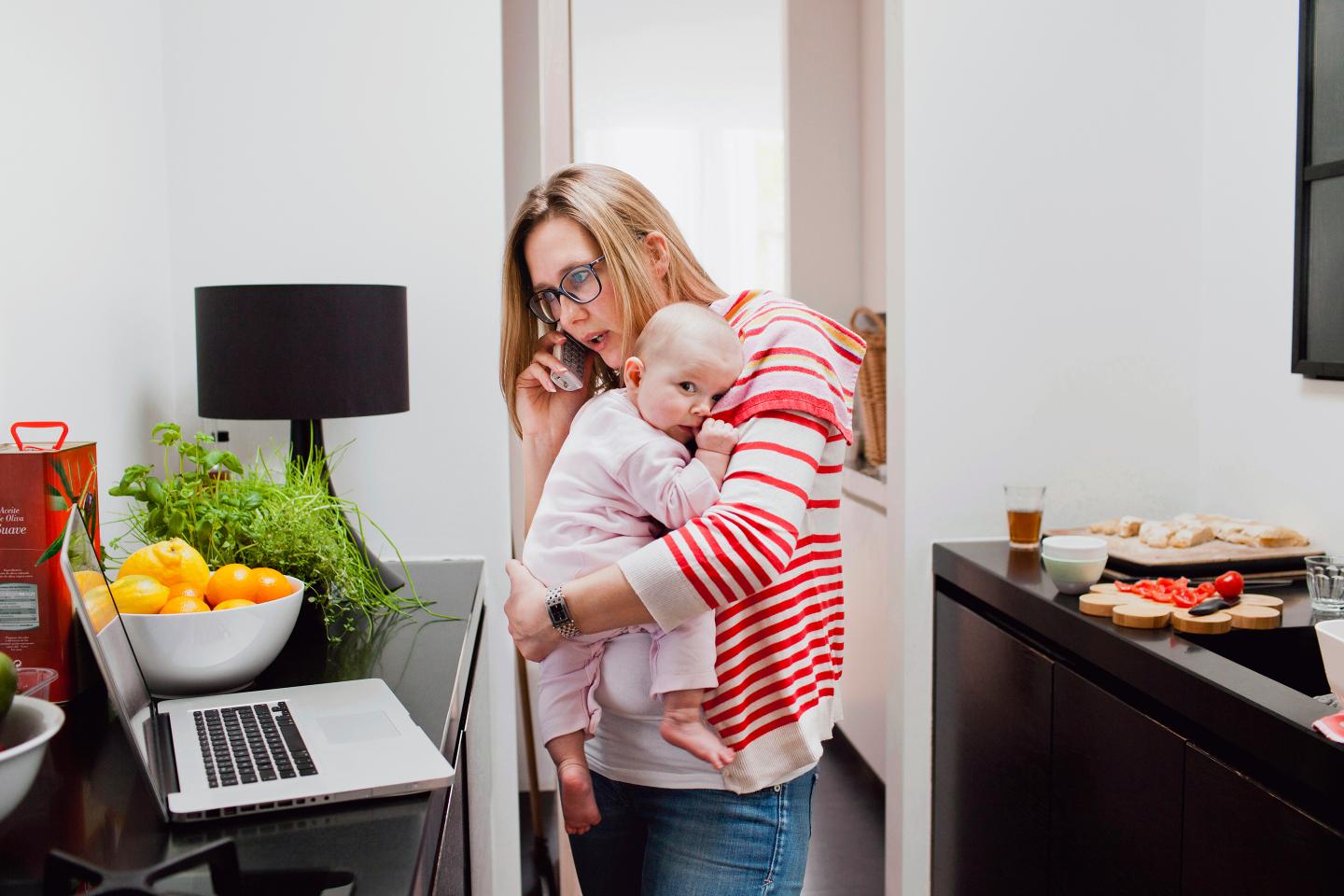 Mother talking on phone and holding baby