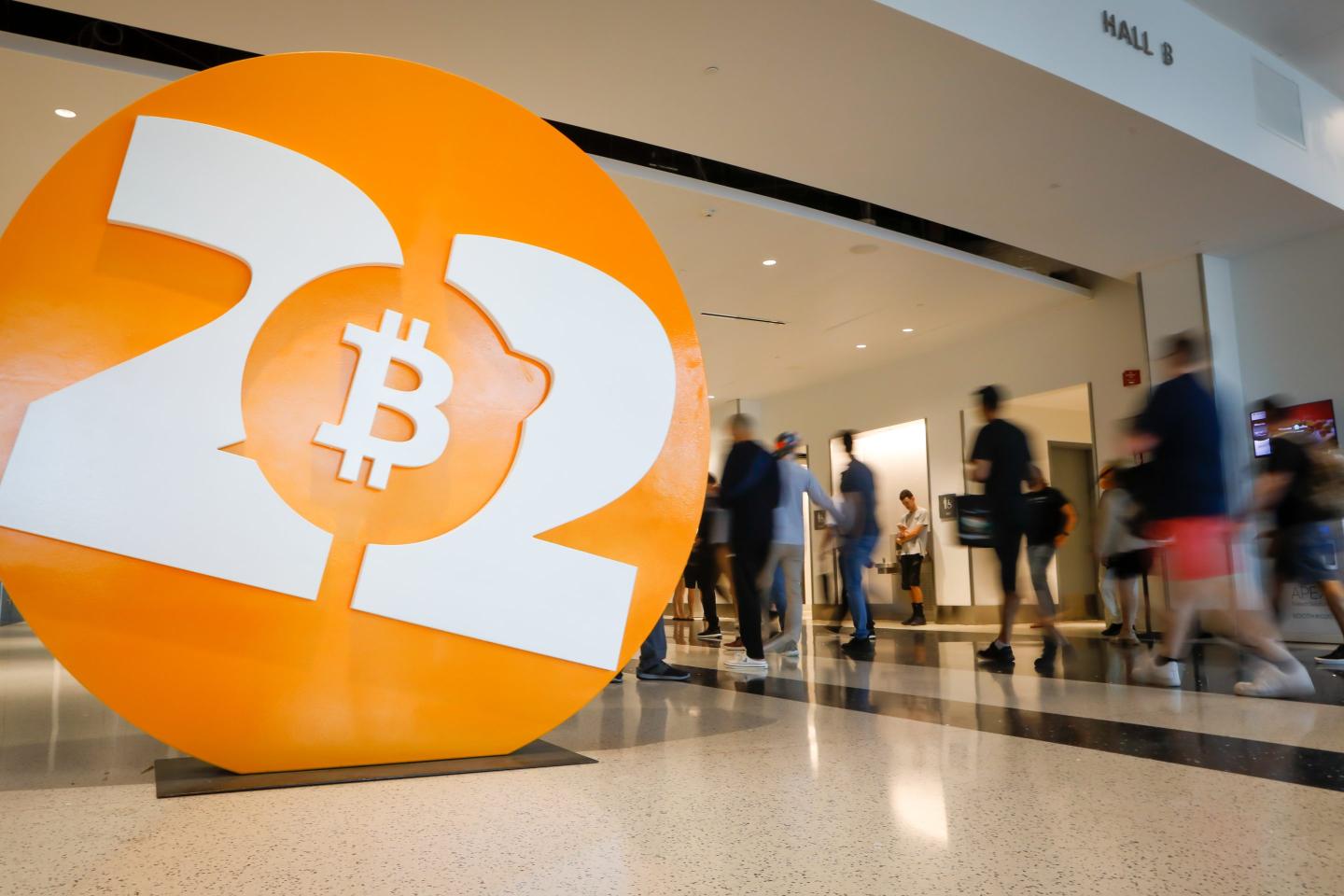 People walk past a Bitcoin 2022 sign at the Bitcoin 2022 Miami conference.
