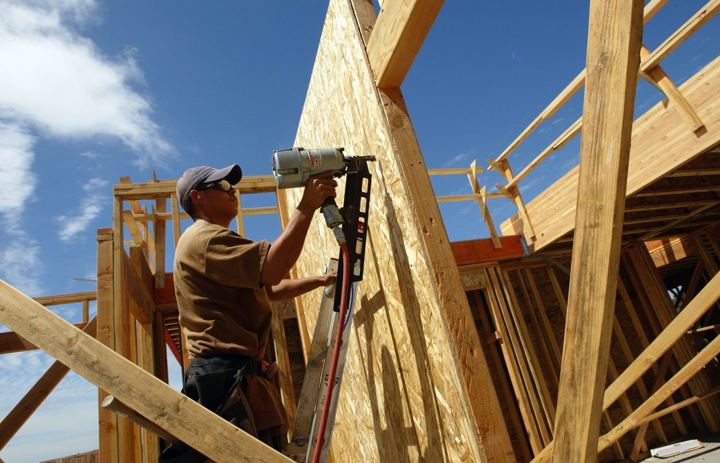 A construction worker frames a house.