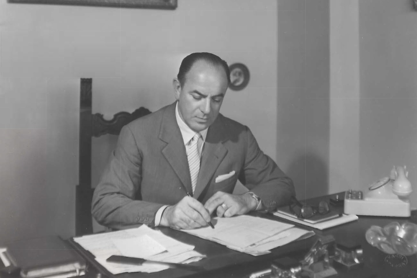 Giacomo Chiesi, the founder of Chiesi Group, in his office at Via Palermo signing some working papers in 1955.