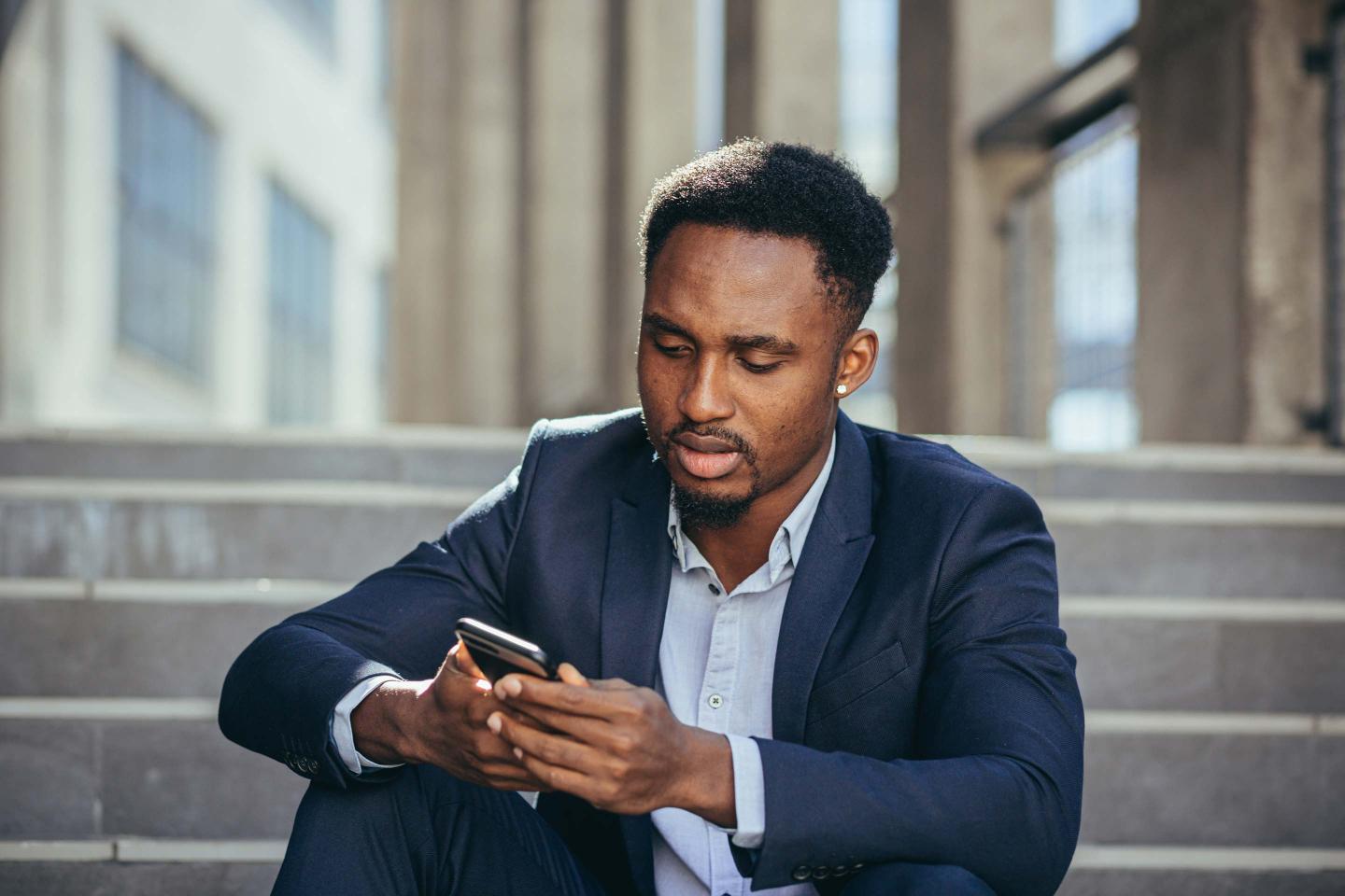 A businessman looking at a cell phone