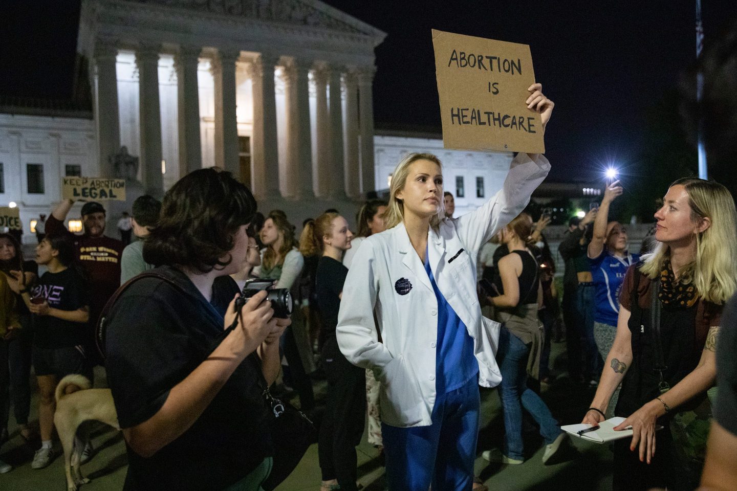 Abortion protester holding a sign that says "abortion is healthcare."