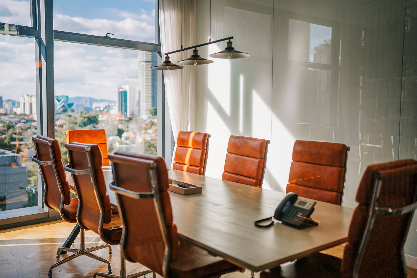 Modern conference room with a big window overlooking city.