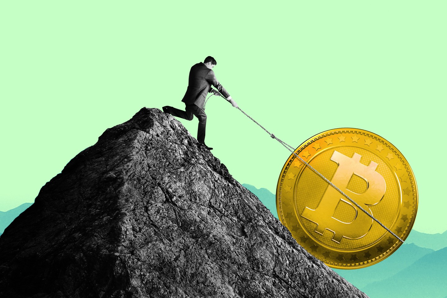 A man uses a rope to pull a large Bitcoin up the side of a mountain top.