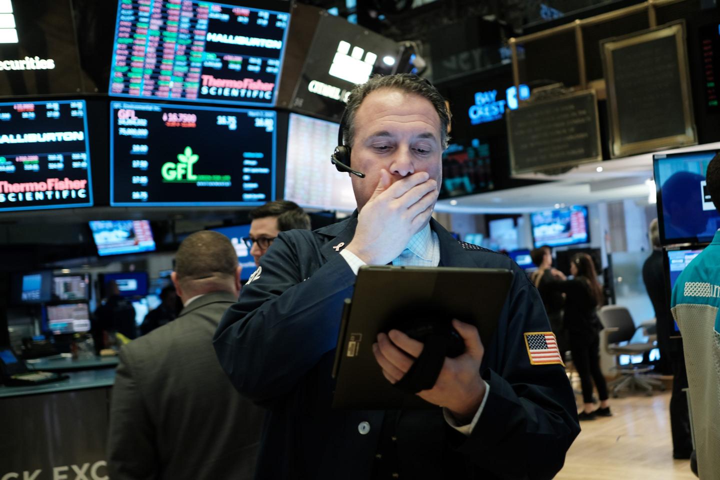 A trader covers his mouth on the floor of the New York Stock Exchange