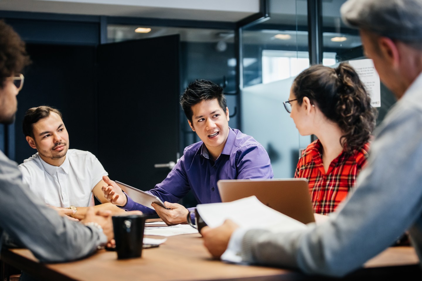 Office managers holding a weekly meeting to discuss the direction of their business in a conference room.