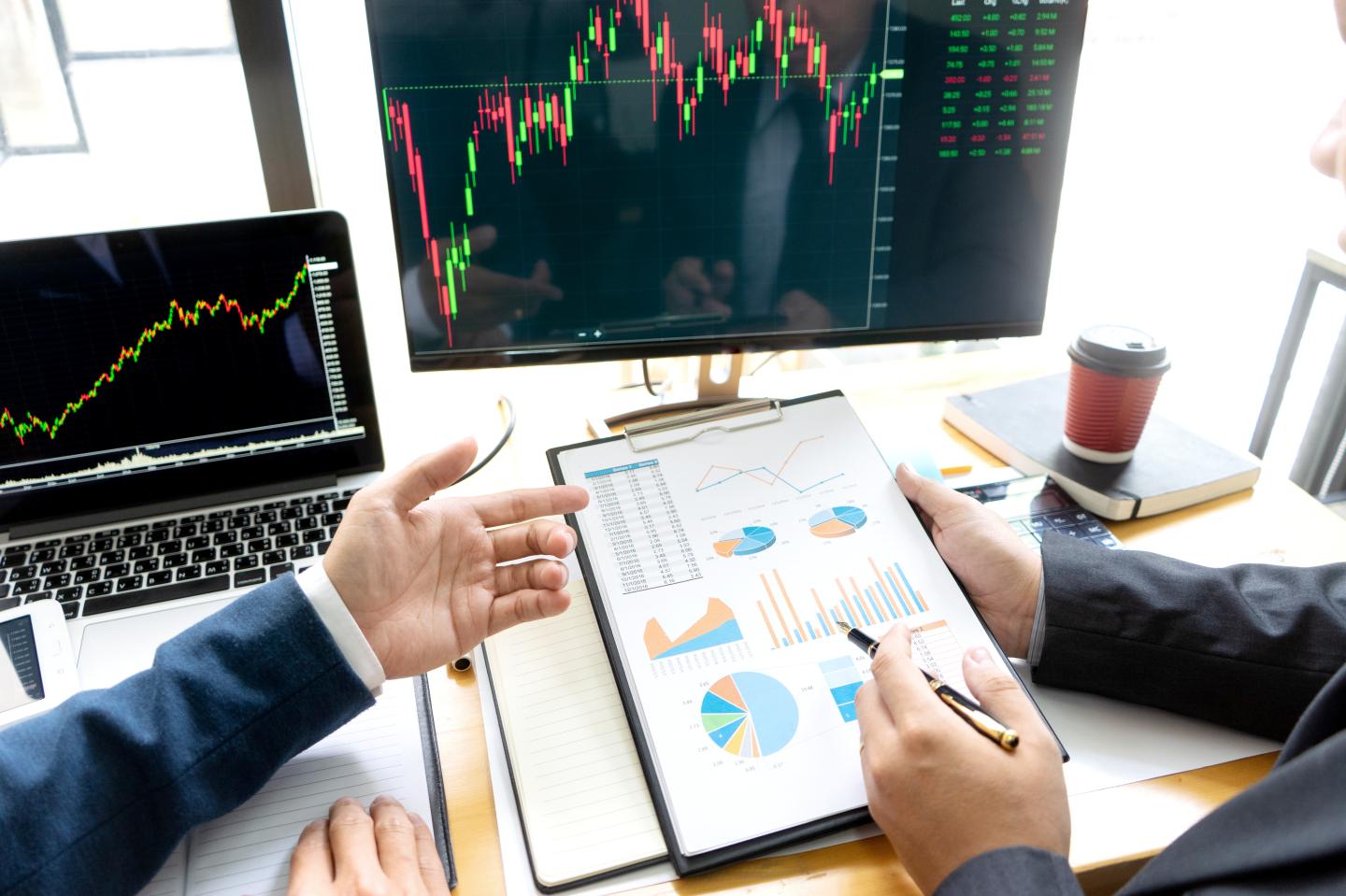 businessman sit at ther table looking at computer laptop in the office , they talking about stock market invest or talk with customer
