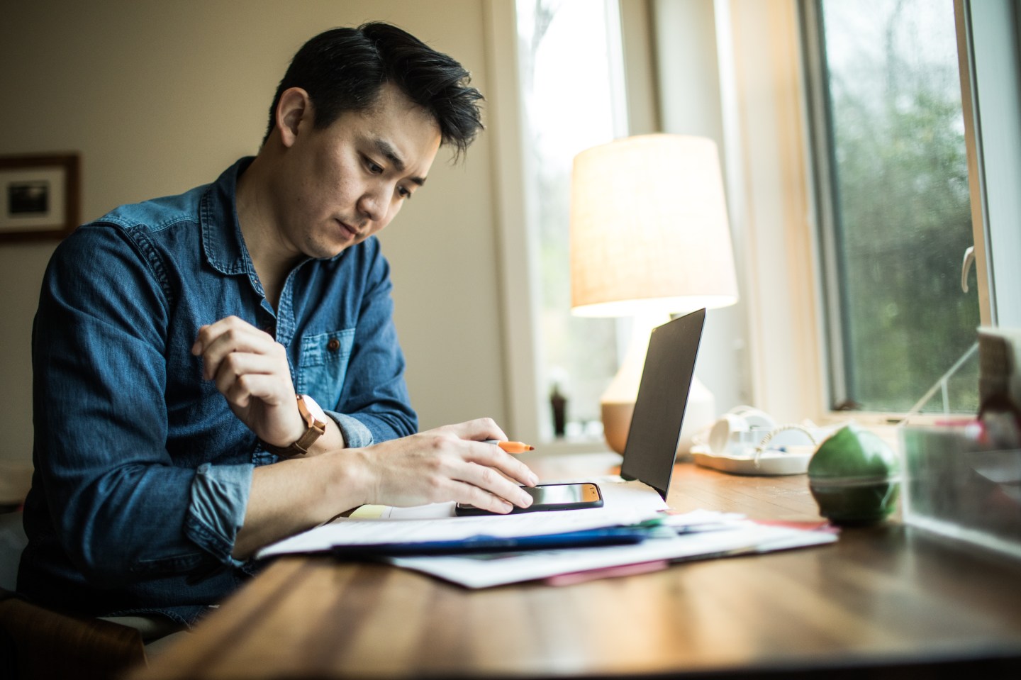 A man is seen working in a home office.