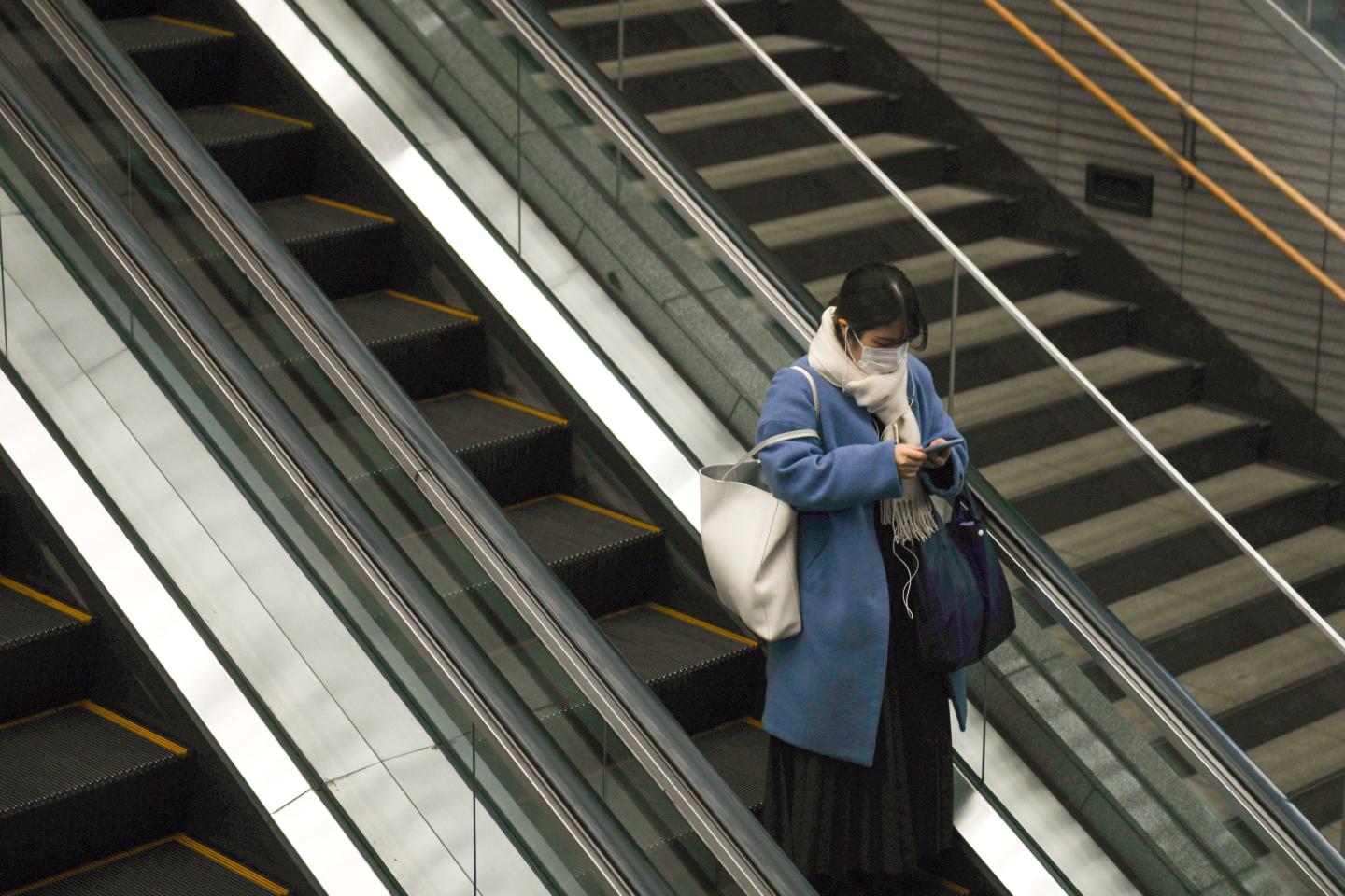 A woman taking an escalator at Yurakucho station in Tokyo, Japa