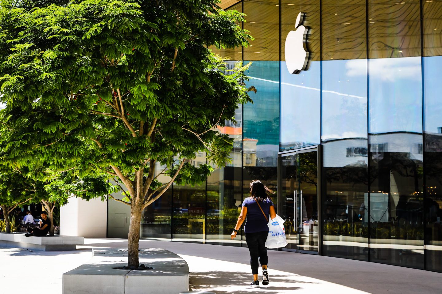 A woman walks past an Apple store in Florida