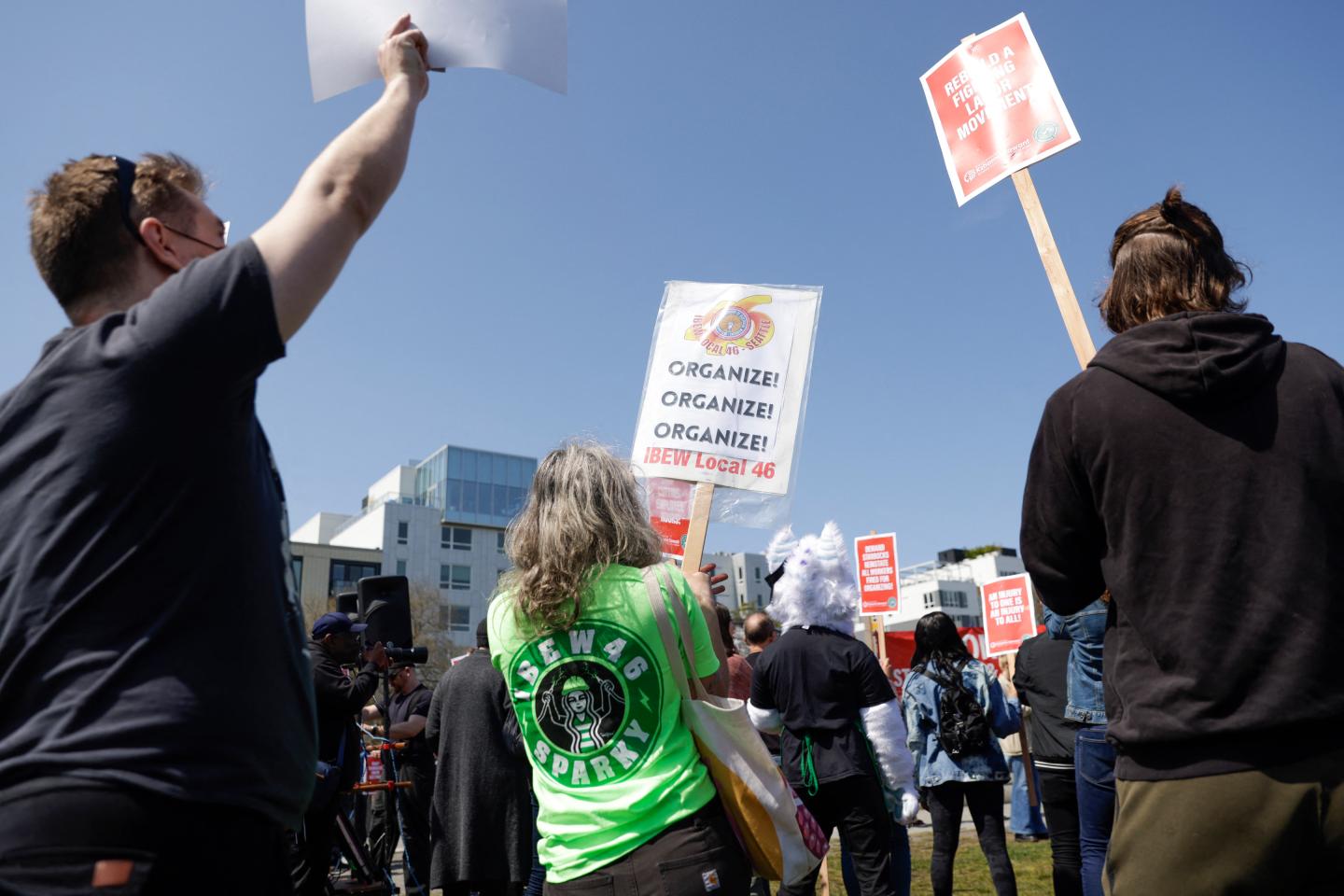 People hold signs during the "Fight Starbucks' Union Busting" rally and march in Seattle.