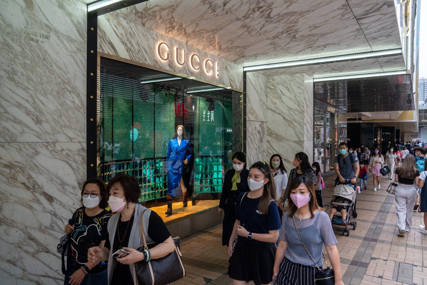 Shoppers in Hong Kong walk past a Gucci store